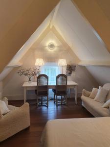 a attic room with a table and two chairs at Chapeau ! in Garderen
