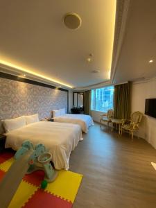 um quarto de hotel com duas camas e uma grande janela em 友愛金色商旅Golden Age Hotel em Taipei