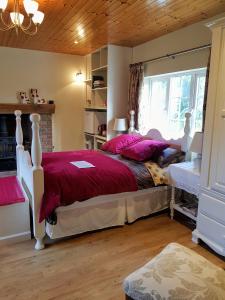 Brookvale في Wellingtonbridge: غرفة نوم مع سرير وملاءات حمراء ونافذة