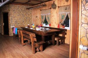 een eetkamer met een houten tafel en stoelen bij Дом с баней для отпуска in Nyzhni Mlyny
