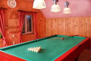 a pool table with billiard balls on top of it at Дом с баней для отпуска in Nyzhni Mlyny