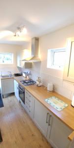 a kitchen with white cabinets and a wooden counter top at Bassett House with 3 bedrooms, fast Wi-Fi and off road parking in Kent
