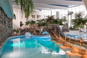 una piscina en un hotel con sillas y un puente en Holiday Club Kuusamon Tropiikki Apartments, en Kuusamo