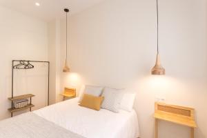 a bedroom with two beds and two pendant lights at GETARIA APARTAMENTUAK - Balentziaga in Getaria