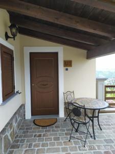 a patio with a table and a brown door at I fiori del Pollino - Guest House in San Severino Lucano