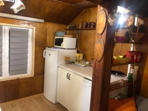 a kitchen with a white refrigerator and a microwave at Letnisko SYMSAR 6, Drewniany domek letniskowy z ogrodem in Wernegity