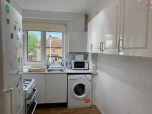 una cucina con lavatrice e forno a microonde di Spacious London Excel 2 bedrooms, Separate Reception, Kitchen, Full Apartment a Londra