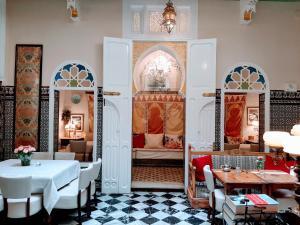 un restaurant avec un lit, des tables et des chaises dans l'établissement El Reducto, à Tetouan