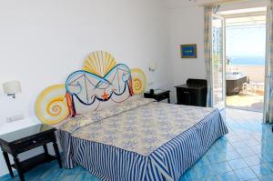 a bedroom with a bed with a colorful head board at Palazzo Marzoli charme Resort - Small Luxury Hotel in Positano