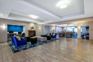 a lobby of a hotel with blue chairs and tables at La Quinta by Wyndham Manteca - Ripon in Ripon