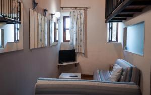 a living room with a couch and a television at Fabrica de Harina in Ventas con Peña Aguilera