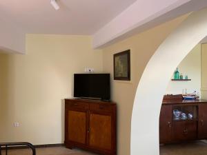 a living room with a flat screen tv on a wooden cabinet at Captain's House Plaka Milos in Plaka Milou