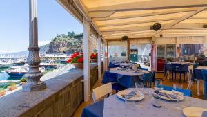 un restaurante con mesas y sillas azules y un puerto en B&B L'Approdo, en Piano di Sorrento