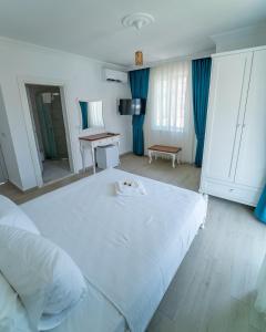 1 dormitorio con 1 cama blanca grande y escritorio en Green Boutique Selimiye, en Selimiye