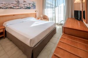 A bed or beds in a room at GHT Oasis Tossa & Spa