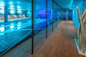 a swimming pool in a building with blue lights at GHT Oasis Tossa & Spa in Tossa de Mar