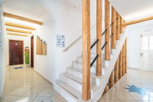 a staircase in a home with wooden beams at Marianna Hotel in Perissa