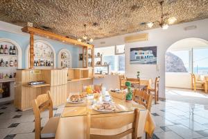 a kitchen and dining room with a table and chairs at Marianna Hotel in Perissa