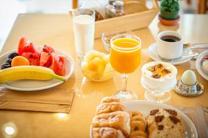 a table topped with plates of food and glasses of orange juice at Marianna Hotel in Perissa