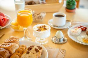 a table topped with plates of breakfast foods and drinks at Marianna Hotel in Perissa