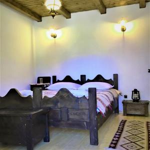 a bedroom with a large wooden bed in a room at Casuta din Valea Regilor in Grădiştea de Munte