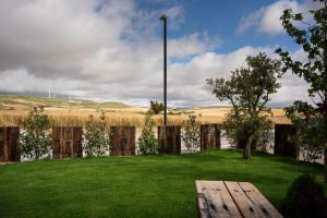 un patio con una valla de madera y un césped verde en Hotel Rural Tierras del Cid, en Quintanadueñas