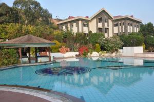 a swimming pool in front of a building at Blue Country Resort in Panchgani