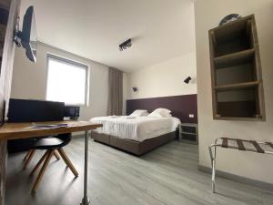 a bedroom with a bed and a desk and a table at Hotel O Ieper in Ypres