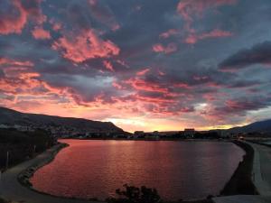 a sunset over a river under a cloudy sky at Apartmani Maja in Pag