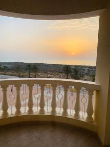 a balcony with a view of a sunset at Wait N Sea !! Sea View Studio Ras Al Khaimah in Ras al Khaimah