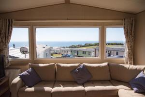 a living room with a couch and a large window at Devon Cliffs Holiday Home in Exmouth