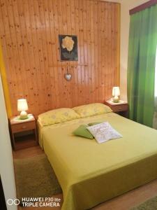 ein Schlafzimmer mit einem Bett und zwei Tischen mit Lampen in der Unterkunft Apartmani Zute in Korčula
