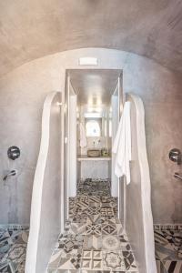 a bathroom with a walk in shower and a sink at Marianna Hotel in Perissa