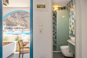 a bathroom with a view of a pool at Marianna Hotel in Perissa
