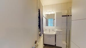 a white bathroom with a sink and a shower at Strandnahe, moderne Ferienwohnung auf Wangerooge, Seeluft 34 in Wangerooge