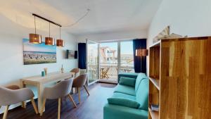a living room with a blue couch and a table and chairs at Strandnahe, moderne Ferienwohnung auf Wangerooge, Seeluft 34 in Wangerooge