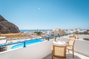 a balcony with a table and chairs and the ocean at Marianna Hotel in Perissa