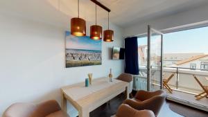 a dining room with a table and chairs and a large window at Strandnahe, moderne Ferienwohnung auf Wangerooge, Seeluft 34 in Wangerooge