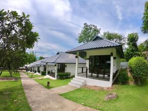 a large white building with a bench in front of it at Diamond Village Pai in Pai