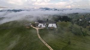 an aerial view of a house on a hill in the clouds at Pensiunea Soarelui in Fundata