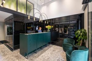 a woman standing behind a counter in a lobby at The Modernist Thessaloniki in Thessaloniki