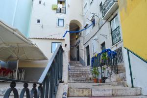 un escalier menant à un bâtiment arborant des drapeaux bleus dans l'établissement Alfama Loft, Santa Apolonia, à Lisbonne