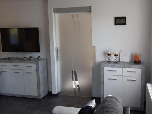 a living room with a television and white cabinets at Ferienhaus Maag in Attendorn