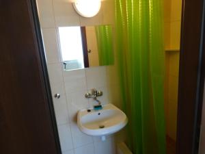 a bathroom with a sink and a green shower curtain at Ośrodek Korab in Władysławowo