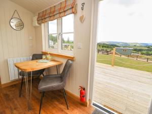 a table and chairs in a room with a deck at Marches Way in Rhayader