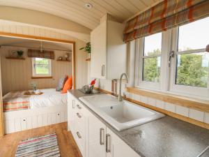 a kitchen with a sink and a bed in a room at Marches Way in Rhayader