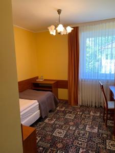 1 dormitorio con cama, escritorio y ventana en Domek - pokoje w domku na Wyspie Sobieszewskiej., en Gdansk