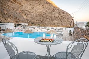 a table and chairs next to a pool at Marianna Hotel in Perissa