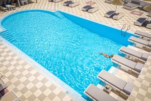an overhead view of a swimming pool with a person in the water at Marianna Hotel in Perissa