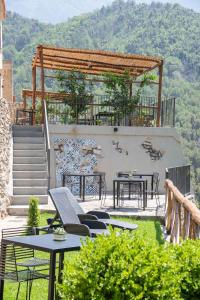 un patio con mesas y sillas y una pared de piedra. en Il Giardino Dorato en Maiori